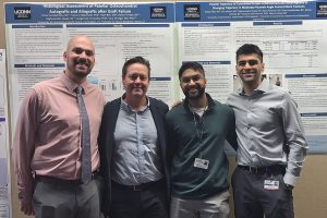 Portrait of four men in front of research posters